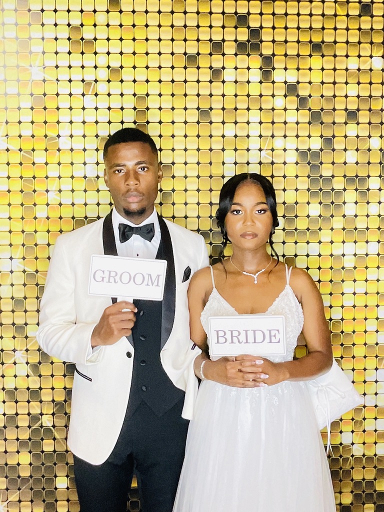 Couple de mariés présentant les panneaux Groom et Bride