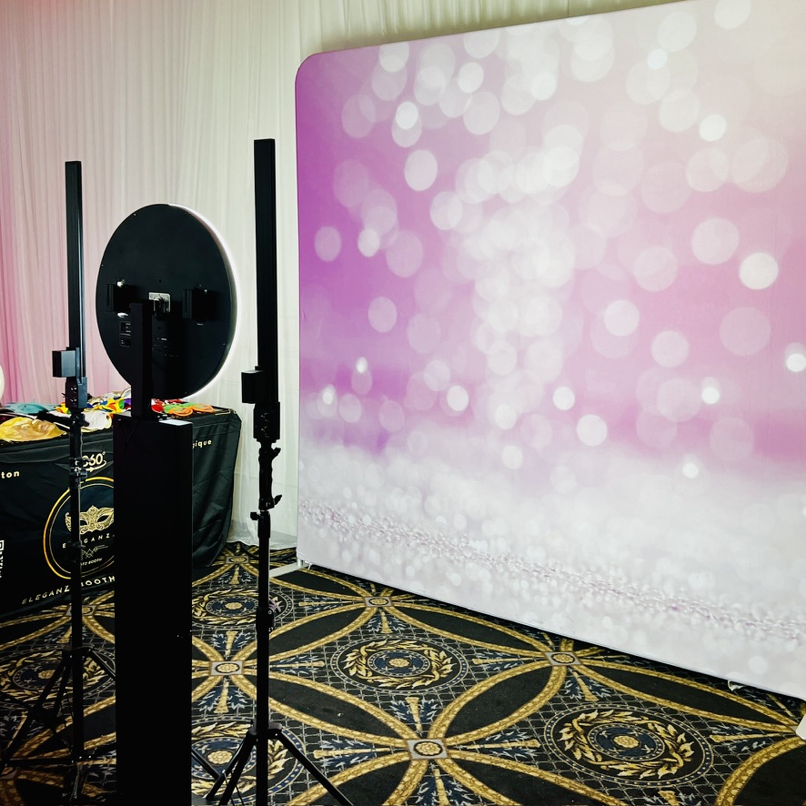 Vue en angle du Photobooth numérique et de sa toile de fond rose
