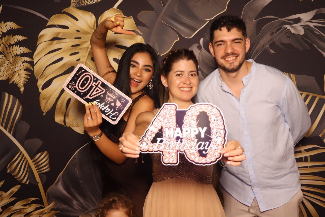 Invités avec un accessoire Happy Birthday devant le photobooth