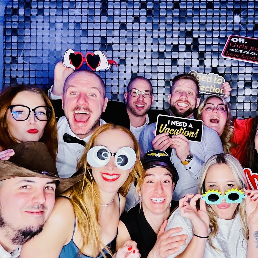 Groupe de collègues avec des accessoires devant le photobooth