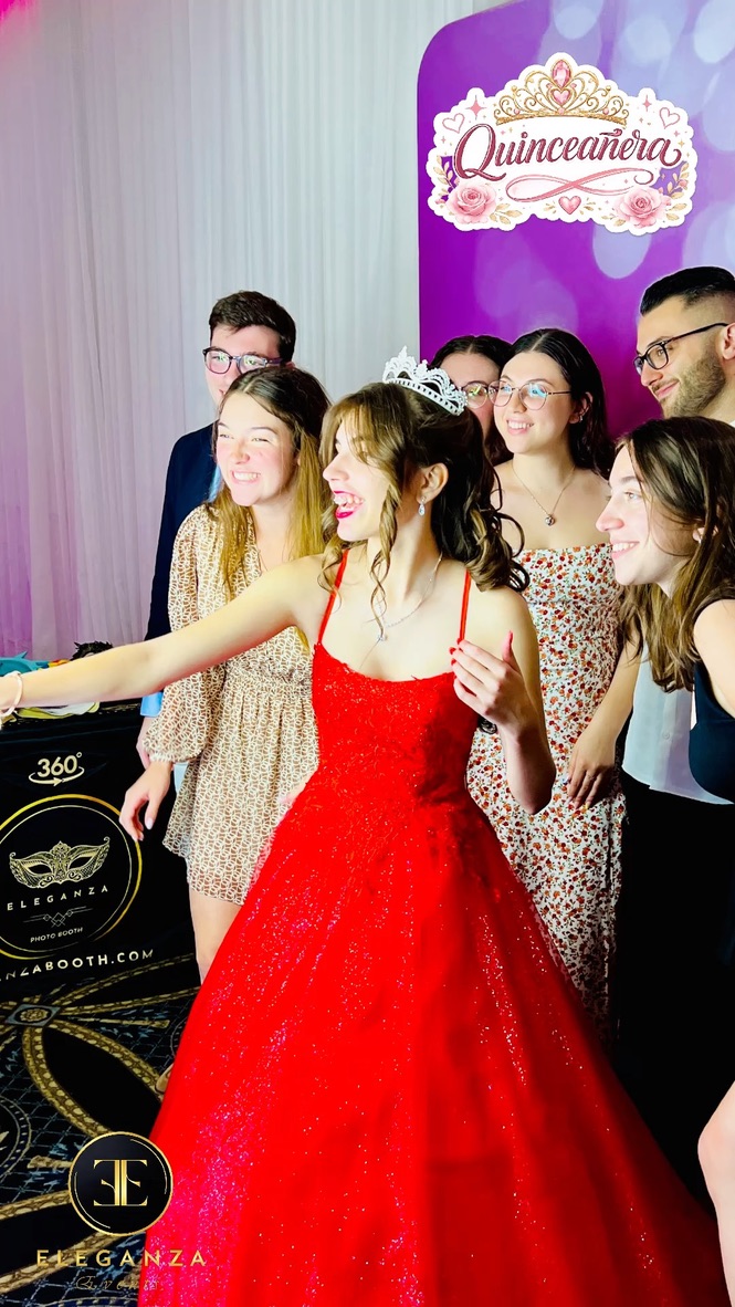 Quinceañera en robe rouge utilisant un photobooth avec ses invités