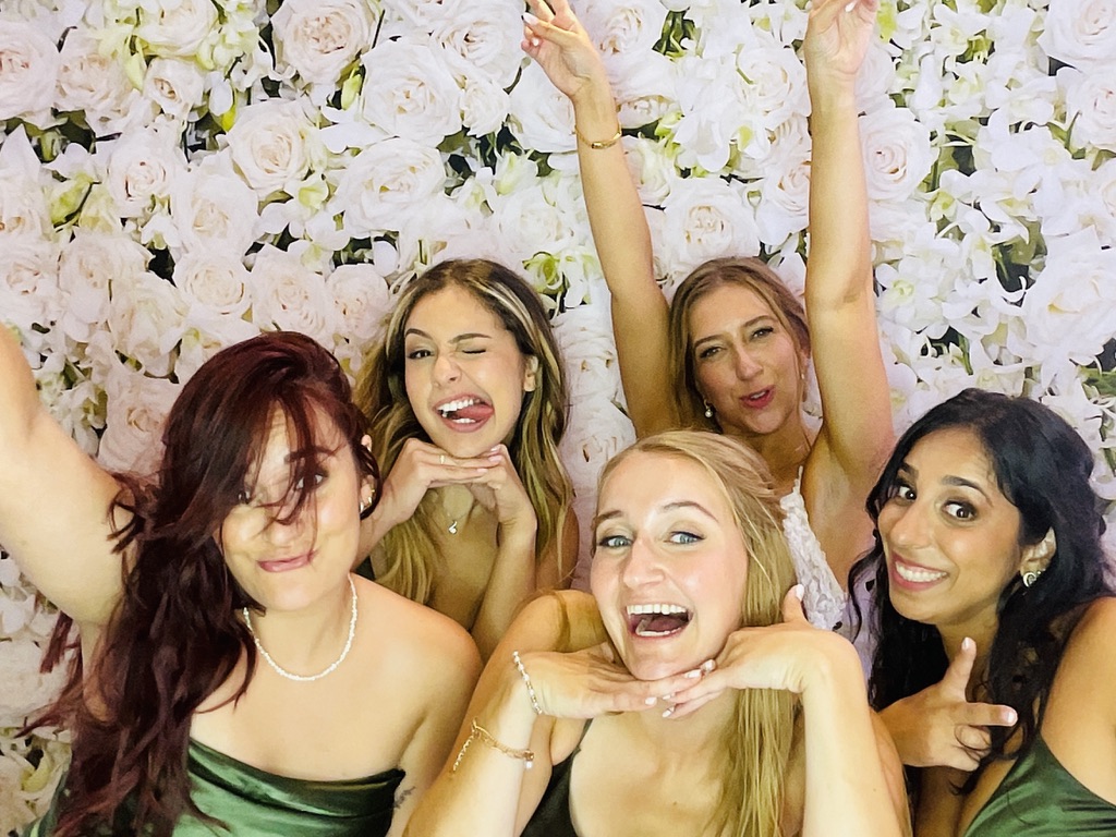 Invitées devant une toile de fond florale lors d’un mariage