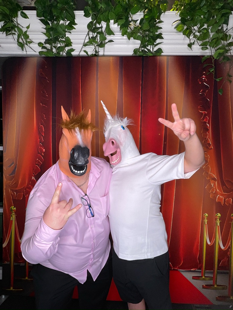 Invités avec masques amusants devant la toile de tapis rouge