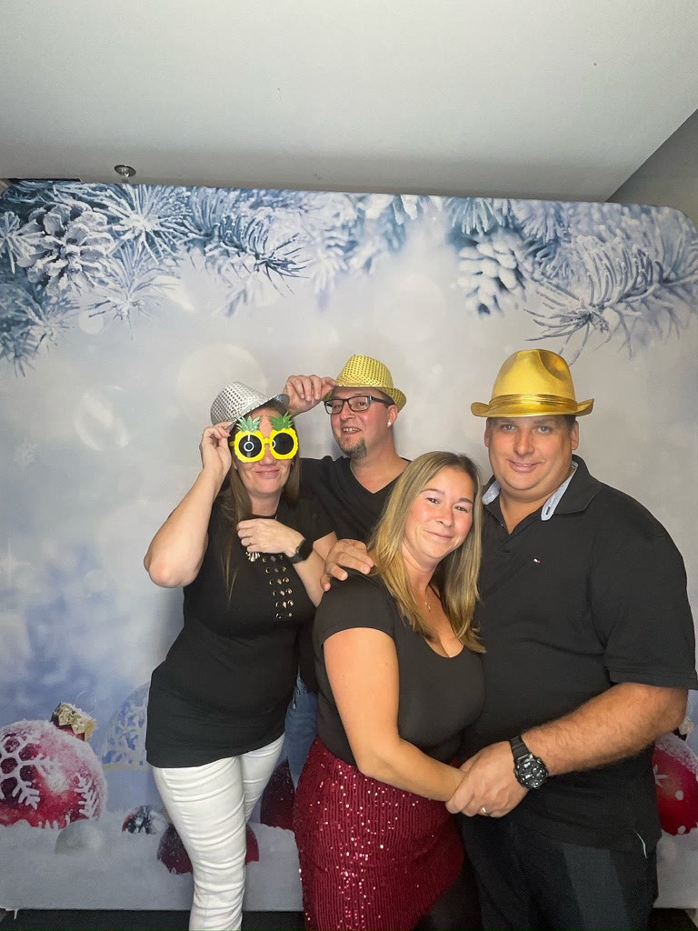 Invités avec accessoires devant la toile de Noël