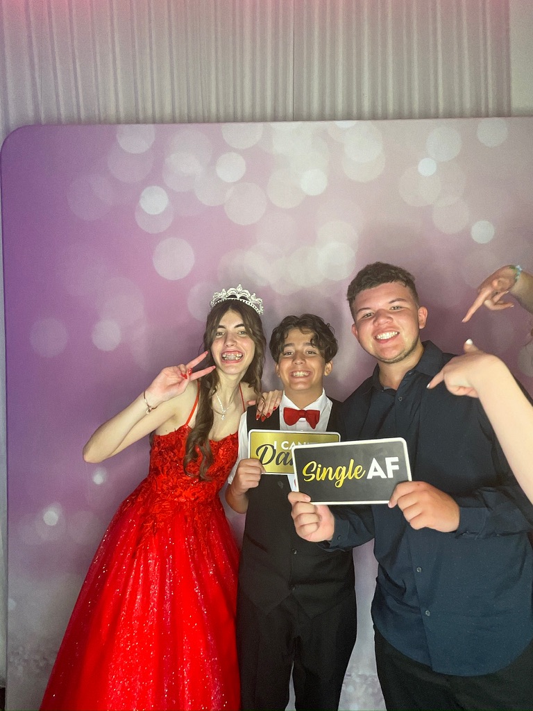 Quinceañera en robe rouge avec deux invités au photobooth numérique